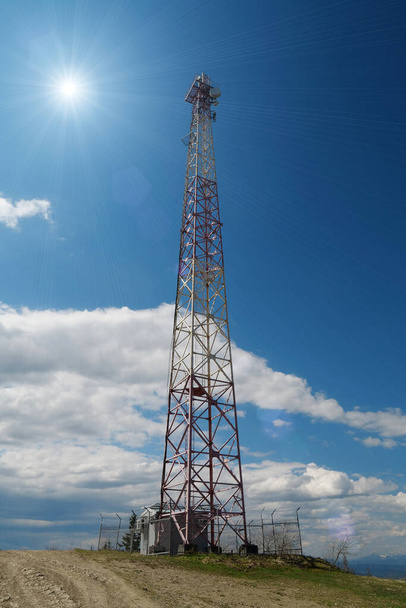 Velká kovová věž na modrém pozadí a slunce - Fotografie, Obrázek