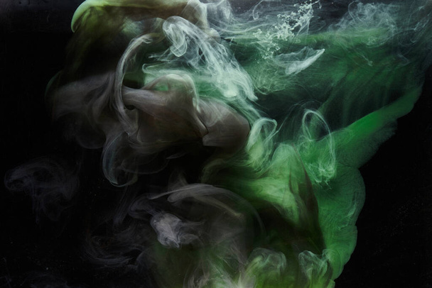 Green smoke on black ink background, colorful fog, abstract swirling emerald ocean sea, acrylic paint pigment underwater - Valokuva, kuva