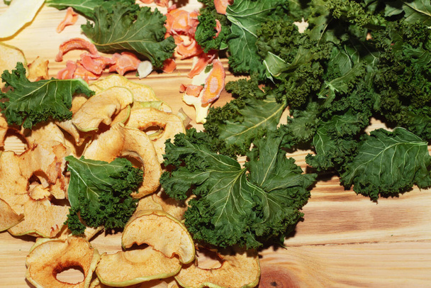 Gemüse, Fruchtchips. Kohl, Zucchini, Möhren und Äpfel auf einem hölzernen Hintergrund. Blick von oben. - Foto, Bild