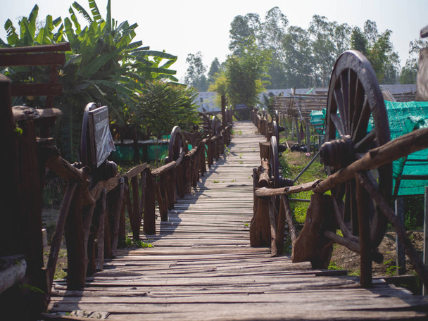 Cart wheels and wooden walkways at temple called "Wat Pipat Mongkol" or "The golden buddha's Building", Thungsaliam, Sukhothai, Thailand in 26 February 2021. - Valokuva, kuva