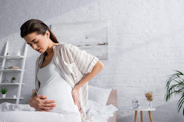 pregnant woman with closed eyes feeling abdominal pain - Zdjęcie, obraz