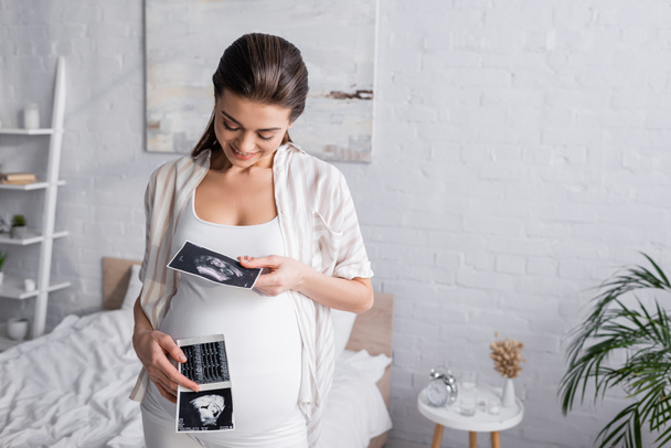 mulher grávida feliz segurando exames de ultra-som  - Foto, Imagem