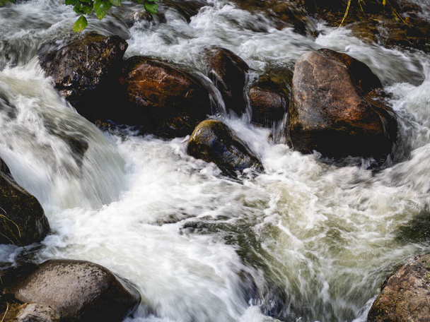 The water is flowing through the rocks. - Foto, imagen
