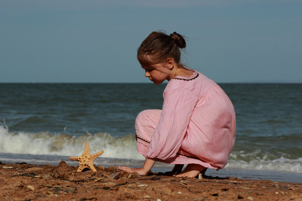 Outdoor image of beautiful little girl playing over sea beach, East Crimea - Foto, Imagem