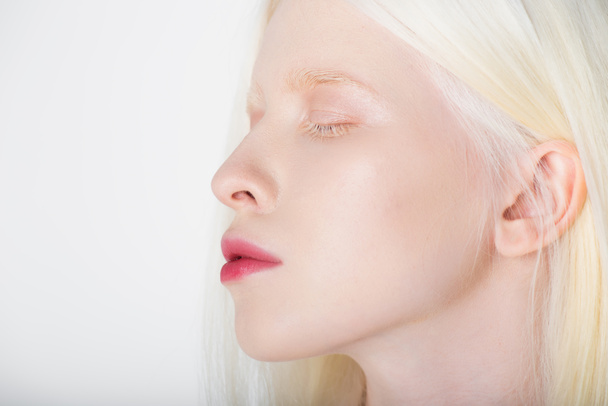 Νεαρή λευκοπαθή γυναίκα που κλείνει μάτια απομονωμένη στα λευκά  - Φωτογραφία, εικόνα