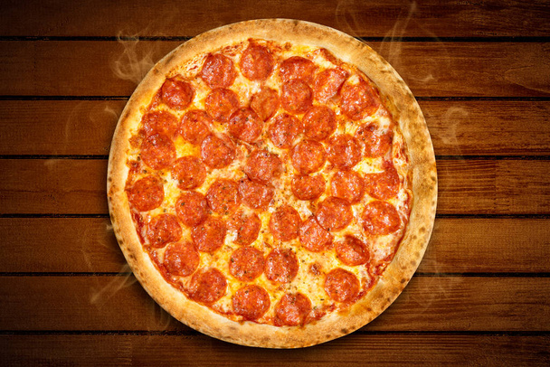 Pizza pepperoni von oben. Heiße Pizza Salami und Mozzarella Käse auf hölzernem Hintergrund für Pizzeria Banner. Flache Lage - Foto, Bild