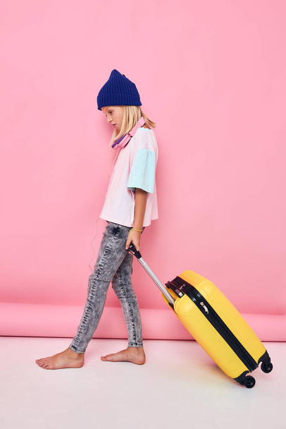 可愛い女の子で青い帽子のスーツケース休暇子供時代 - 写真・画像
