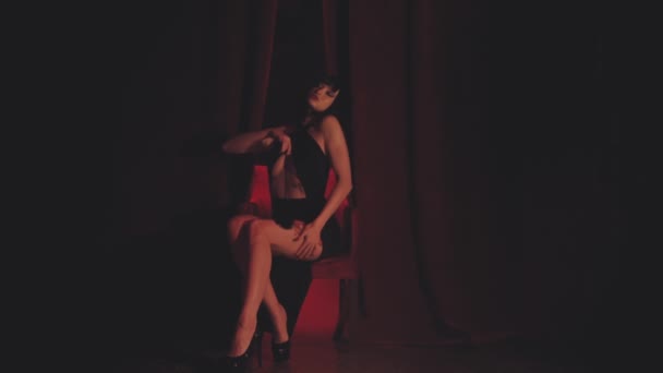 Αισθησιακή κυρία κάθεται σε κόκκινη καρέκλα - Πλάνα, βίντεο