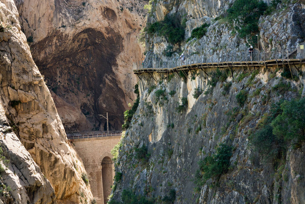 En el Caminito del Rey. Caminantes caminan por la pasarela que domina el vertiginoso y estrecho cañón de las gargantas Gaitanes - Foto, Imagen