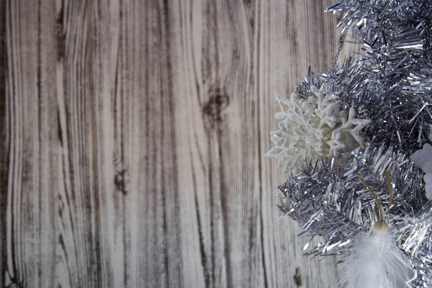 Trendikäs joulutausta. Hopea joulukuusi ja pörröinen höyhenet koristeet puinen tausta. Pörröinen ja pörröinen, tekoturkiskonsepti. Kopioi tilaa. Laadukas kuva - Valokuva, kuva