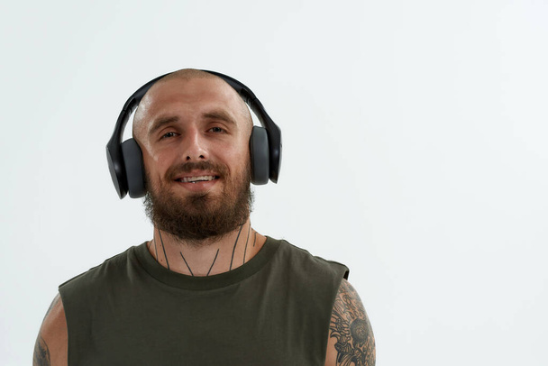 Young european man listening music in earphones - Фото, изображение