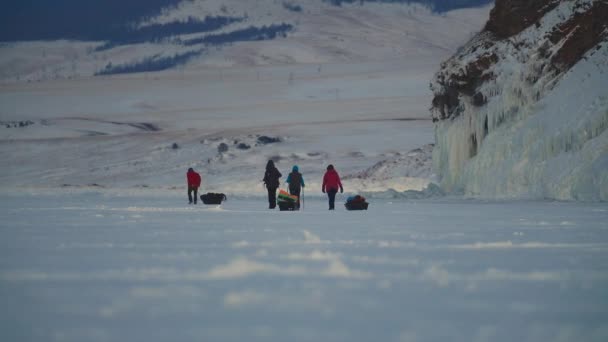Spedizione invernale, la gente in marcia da trekking tira slitte sul paesaggio innevato - Filmati, video