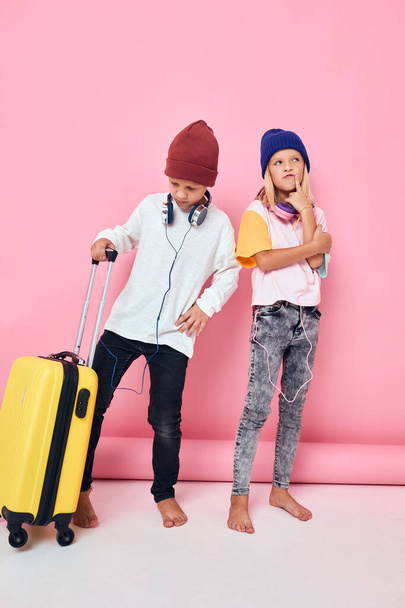 funny little boy and girl stylish clothes suitcase headphones studio posing - Foto, immagini