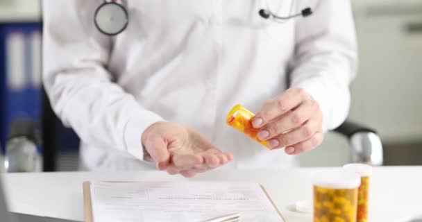 Dokter gieten veel capsules van de geneeskunde uit pot in zijn hand 4k film slow motion - Video