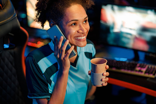 Woman gamer uses cellphone in cyber club - Fotoğraf, Görsel