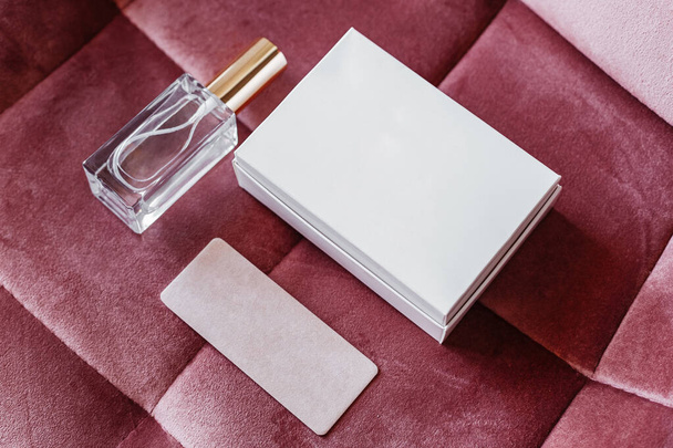 a bottle of perfume and a packing box with a business card on a velour background - Photo, Image