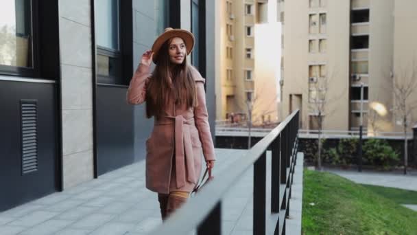 Mulher de casaco e chapéu andando pelas escadas do prédio de escritórios fundo - Filmagem, Vídeo