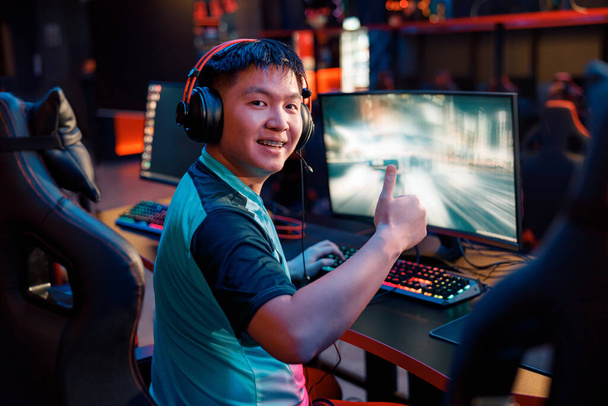 Азиатский геймер доволен своей игрой в киберклубе - Фото, изображение
