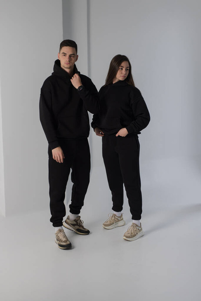 Couple posing in studio wearing black hoodie costumes - Foto, immagini