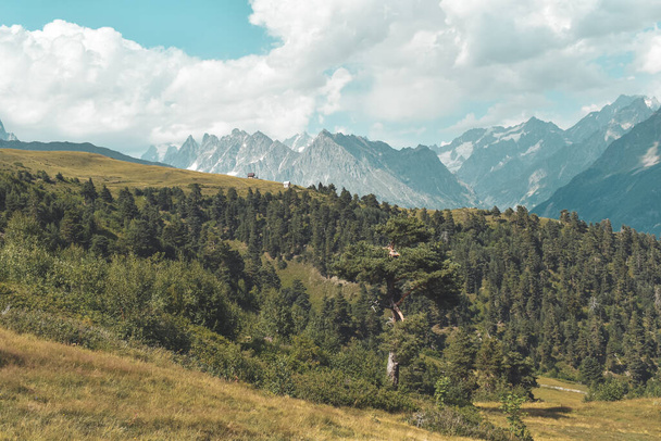 Paisaje de montaña de verano cerca de Mestia, región de Svaneti, Georgia, Asia. Montañas nevadas al fondo. Cielo azul con nubes arriba. Georgiano destino de viaje - Foto, Imagen