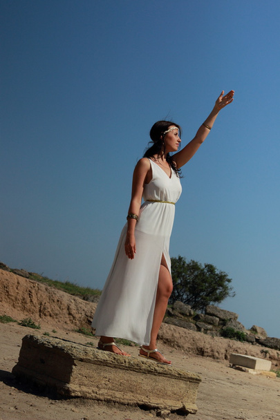 çekici kadın Yunan tanrıçası tarzı lüks elbise günbatımı yakınındaki antik kalıntılar üzerinde açık - Fotoğraf, Görsel