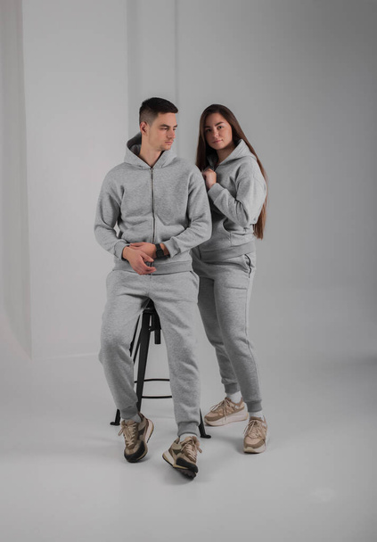 Couple posing in studio wearing grey hoodie costumes - Zdjęcie, obraz