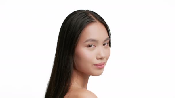 Πορτρέτο της ελκυστική ασιατική κυρία με καστανά μαλλιά, λευκό φόντο - Πλάνα, βίντεο