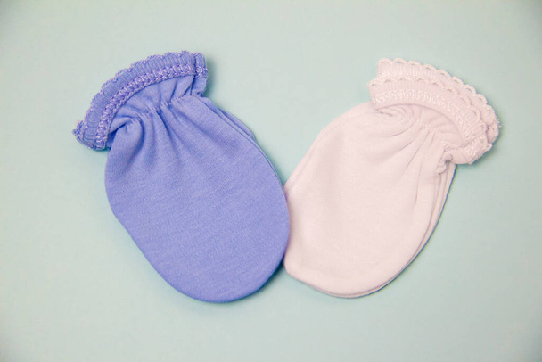 mittens bags for newborns on a gray background. Birth of a child. shopping for clothes for newborns - Fotó, kép