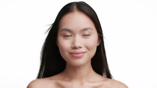 Veselé asijské ženy s létající dlouhé brunetky vlasy, bílé pozadí - Záběry, video