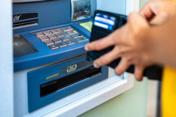withdraw cash from an ATM on a city street - Photo, Image