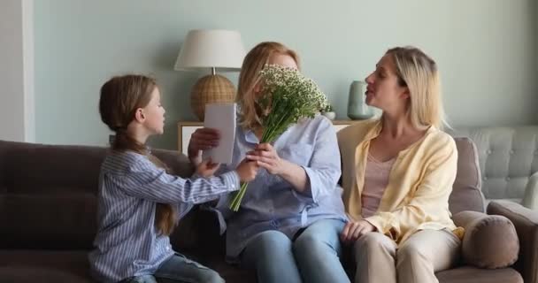 Smiling mum child give March 8 gift flowers to granny - Filmagem, Vídeo