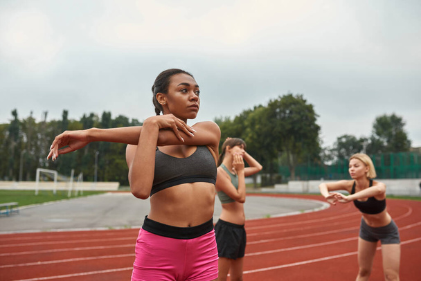 Young sports girls stretching before run training - Valokuva, kuva