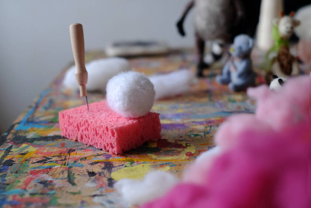 Aguja en un cubo de fieltro en una esponja rosa. Accesorios para fieltro aguja, tejido de lana artesanal por pelo de oveja. .. Foto de alta calidad - Foto, Imagen