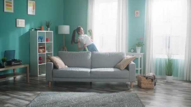 La mujer enérgica está bailando y limpiando apartamento - Imágenes, Vídeo