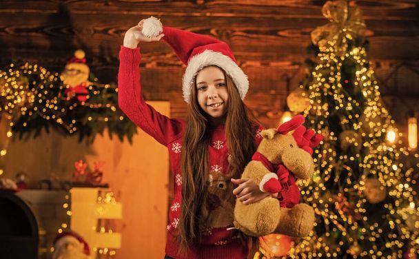 Winter holidays. cheerful kid in santa costume. child love xmas. happy little girl hold reindeer toy present. new year party celebration. its christmas time. the best gift ever. childhood happiness - Foto, imagen