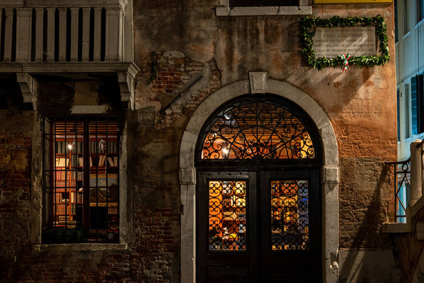 Gece, Venedik, İtalya 'da aydınlatılmış eski bir kitapçı. - Fotoğraf, Görsel