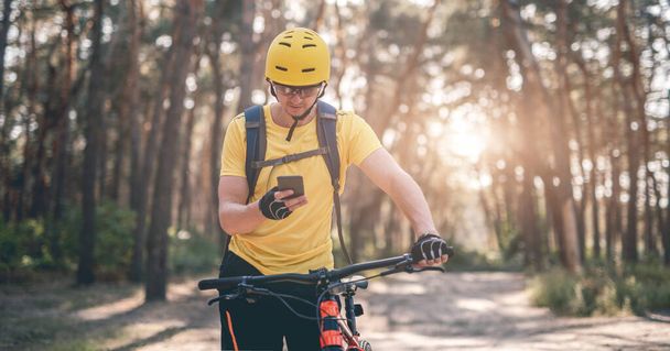 Cyclist checking route on smartphone - Valokuva, kuva
