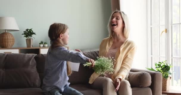 Happy little girl greet mommy on Mothers Day with flowers - Materiał filmowy, wideo