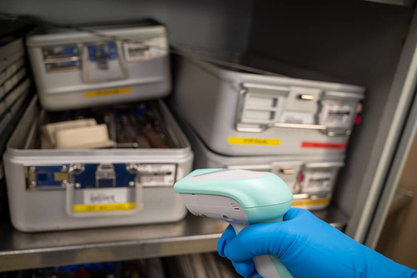 algunos contenedores de instrumentos se detectan en un quirófano con un escáner de mano - Foto, Imagen