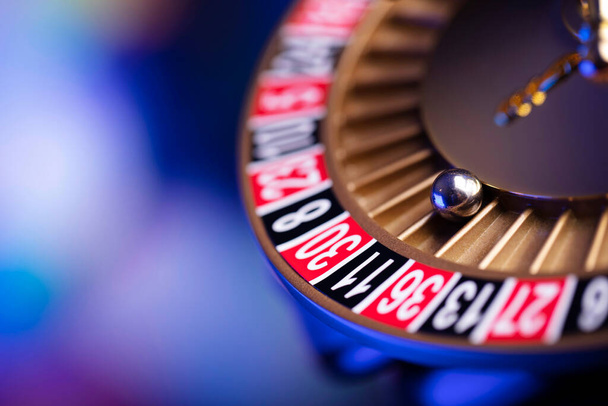 Casino theme.  Roulette wheel, poker chips and dice on  colorful bokeh background. - Photo, Image
