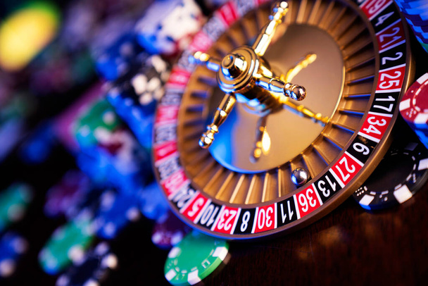Casino theme.  Roulette wheel, poker chips and dice on  colorful bokeh background. - Фото, изображение