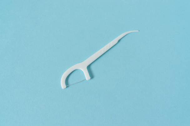A dental floss picks on blue background. - Foto, afbeelding