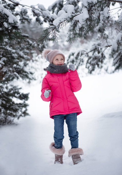 Niño en invierno. Una niña pequeña, jugando en el invierno afuera. Un hermoso retrato infantil de invierno. Niño feliz, diversión de invierno al aire libre. - Foto, imagen