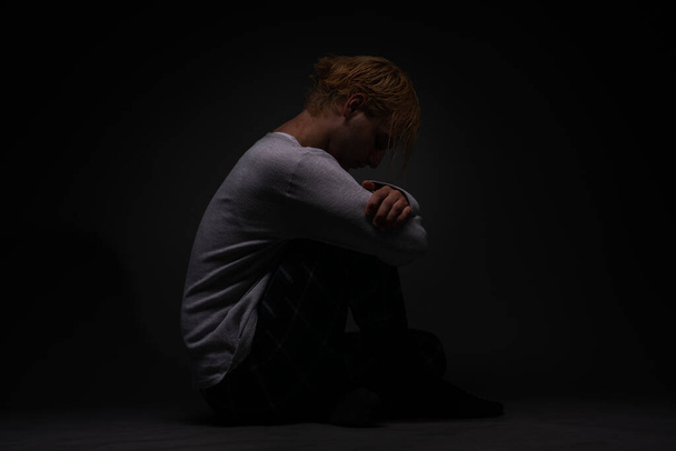 Депресивний хлопчик сидить і думає про свій смуток
 - Фото, зображення
