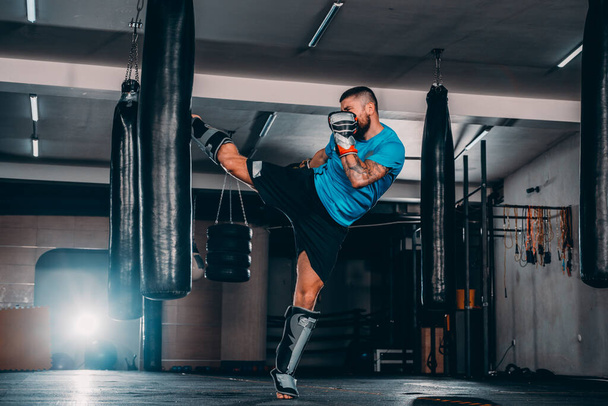 Fiatal izombunyós bokszzsákot használ a tornateremben. Boxer üti boksz sebesség táska - Fotó, kép