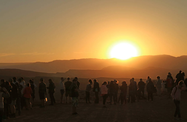 Sylwetka wielu gości na klifie oglądających zachód słońca w Valle de la Luna na pustyni Atacama, Rezerwat Narodowy Los Flamencos, północne Chile - Zdjęcie, obraz