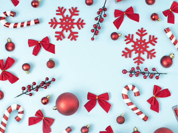 Composición navideña. Decoraciones rojas sobre fondo azul pastel. Navidad, invierno, concepto de año nuevo. Plano, vista superior, espacio para copiar. - Foto, imagen