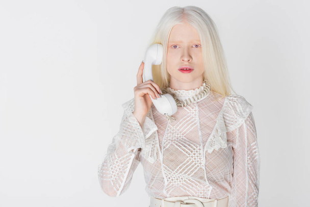 Κομψό αλμπίνο γυναίκα μιλάει στο τηλέφωνο απομονώνονται σε λευκό  - Φωτογραφία, εικόνα