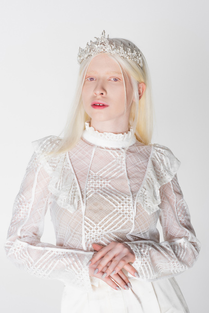 Joven modelo albino en corona mirando a cámara aislada en blanco - Foto, imagen