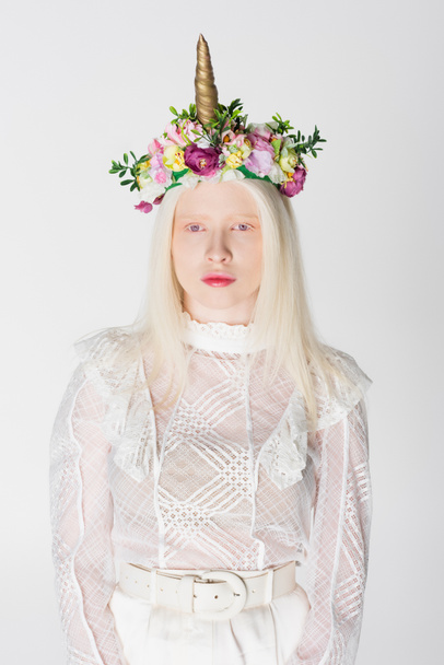 Mujer albina con estilo en blusa guipur y corona con flores y cuerno aislados en blanco - Foto, Imagen